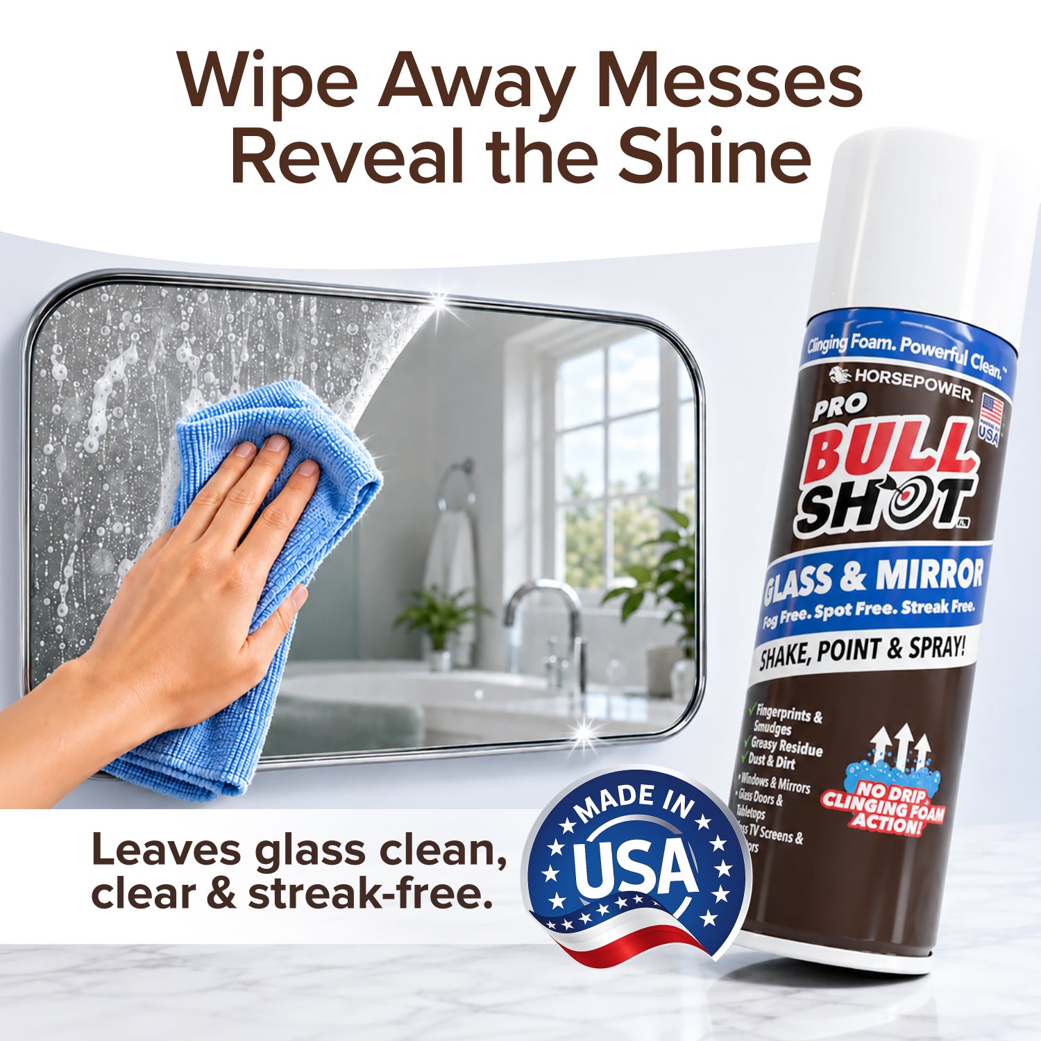 A hand wipes a bathroom mirror with a blue cloth, removing streaks. Beside the mirror is Bull Shot Glass & Mirror Cleaner, offering a streak-free shine. Text highlights it's made in the USA and works as an effective glass cleaner.